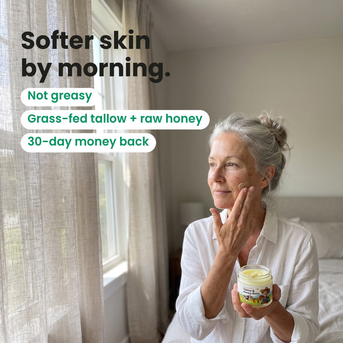 A woman pressing Tallow & Honey Balm into her cheek, holding the open jar